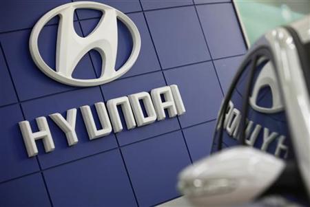 The Hyundai logo is seen next to the company's Sonata sedan at a dealership in Seoul February 24, 2010. REUTERS/Lee Jae-Won
